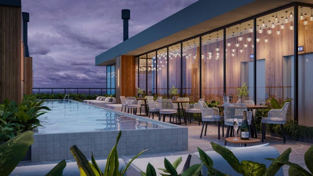 Piscina noturna em área externa do Pantai Brava Residence.